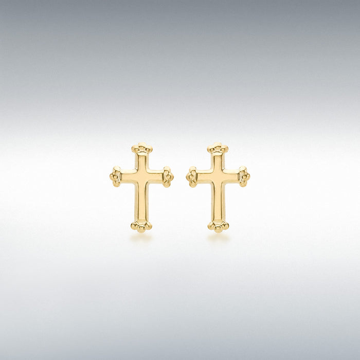 Gold cross-shaped earrings for children on a light gray background