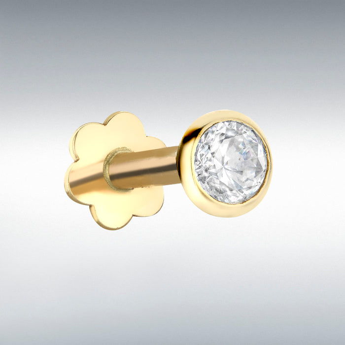 Gold labret stud with a clear gemstone on a gray background