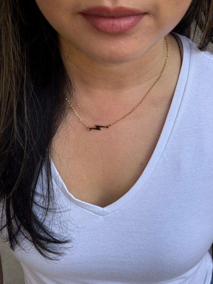 Model wearing gold lightning bolt necklace by Ladyspinedoc