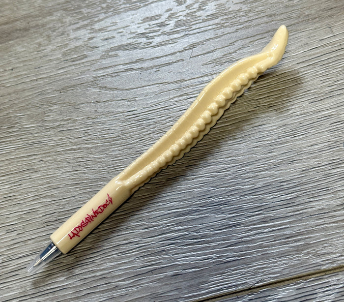 Close-up of the Spinal Stylus Pen resting on wood surface, showcasing spine design and hot pink logo.